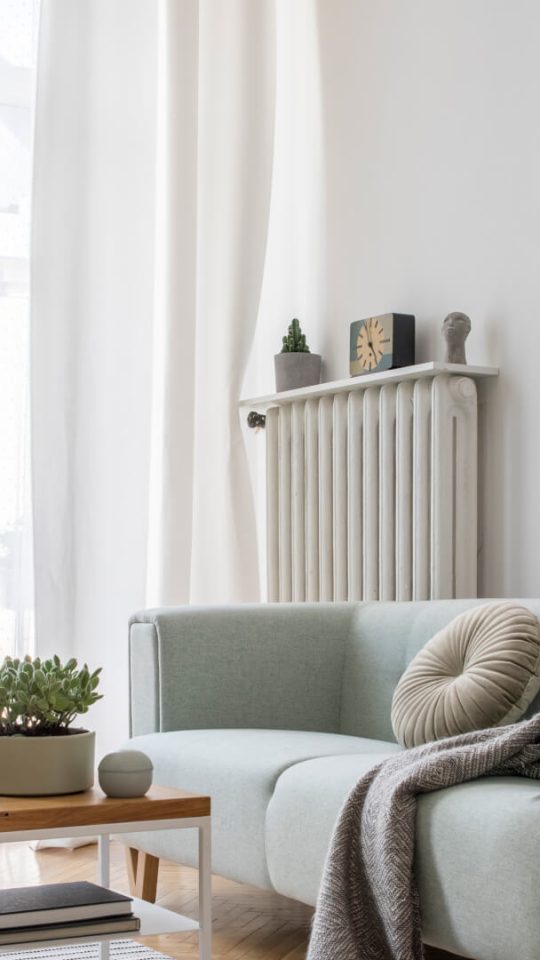 a living room with a couch, coffee table and plants at The  Hargrove at Southpoint