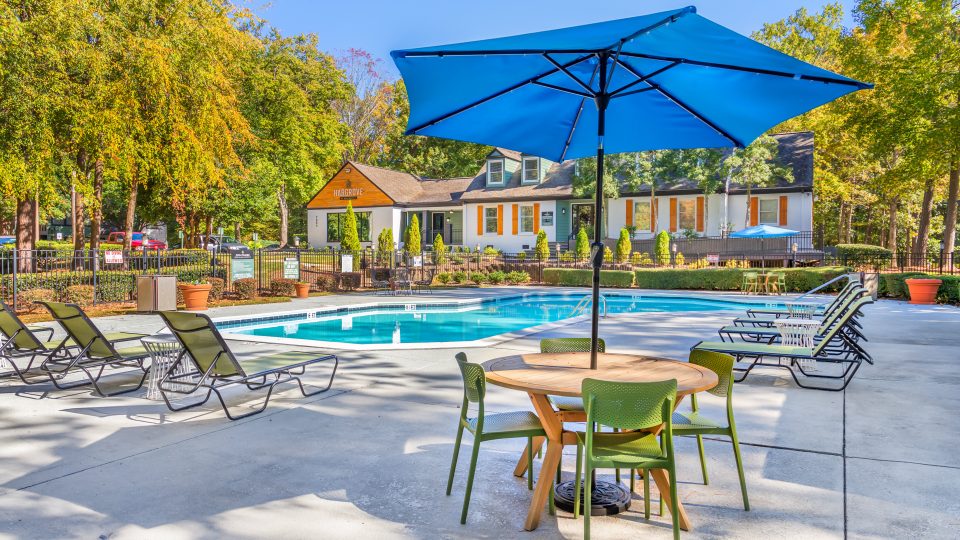 a pool with chairs and umbrellas near a patio at The  Hargrove at Southpoint
